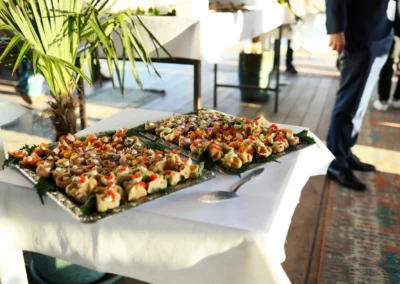 Gourmet appetizers at a stylish indoor event with attendees in formal attire.